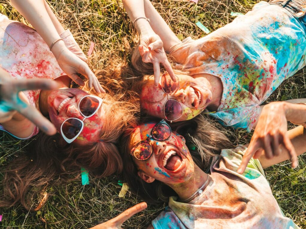 Three girls lie on the grass in paints