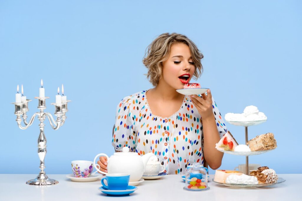 Beautiful woman with sweets over blue wall