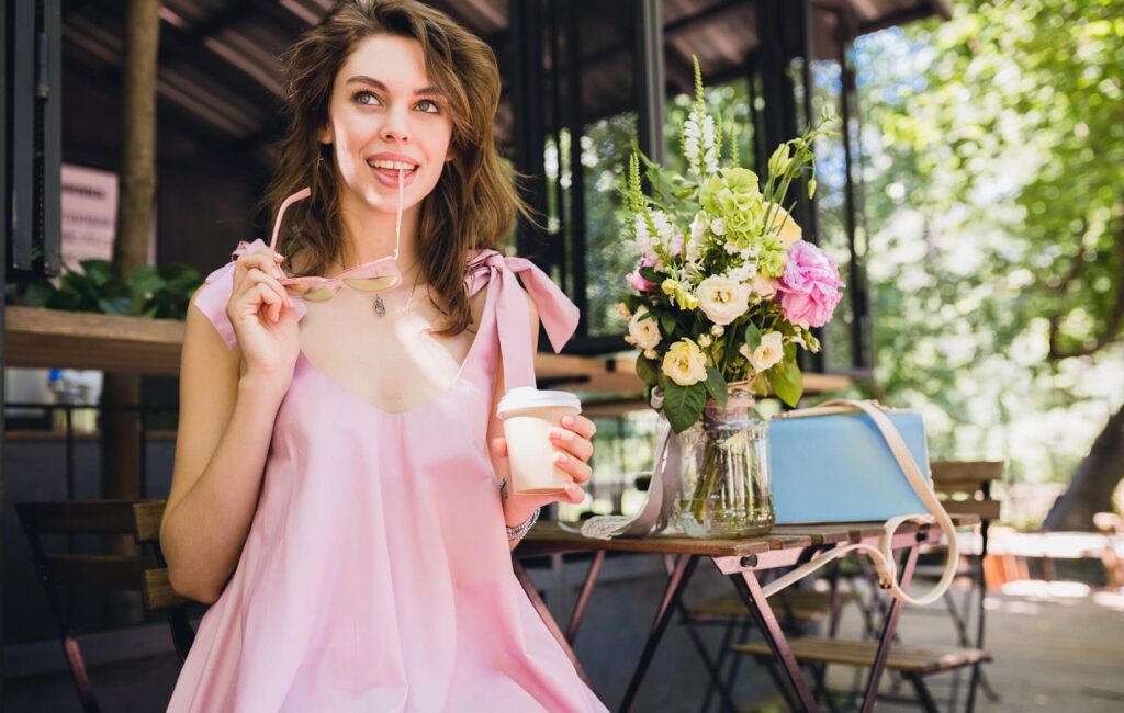 Woman sitting in a cafe in a summer outfit