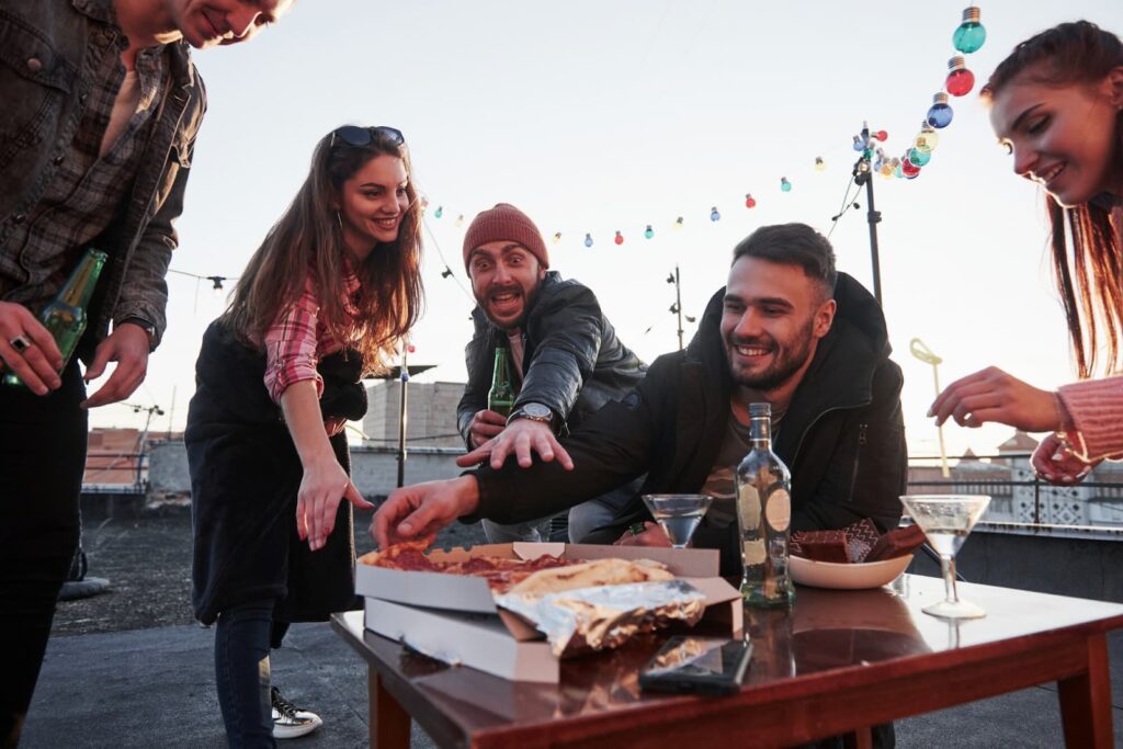 People eating pizza outdoors