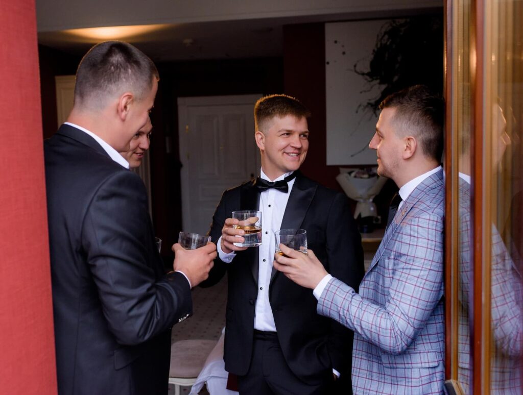 Groom's friends in suits drinking