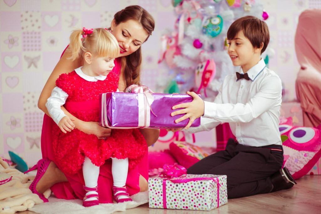 Mother and children opening gifts